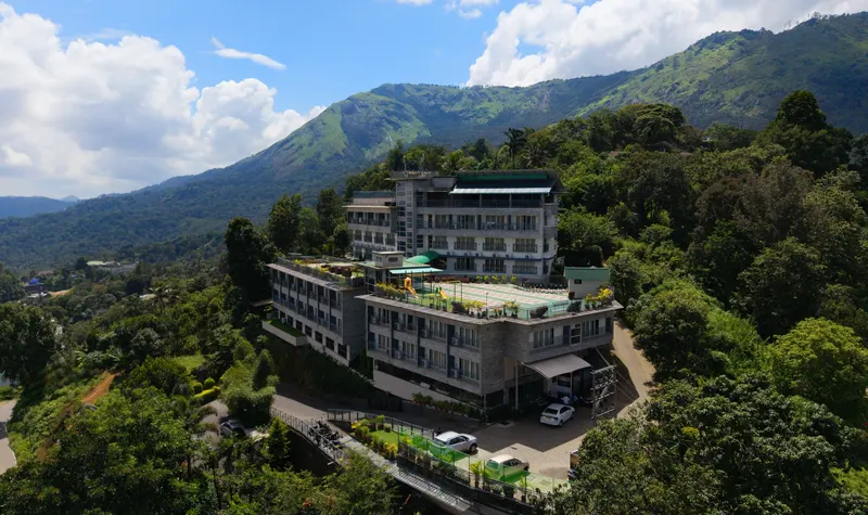 The resort from the air, its terraces stepping down a green hillside below the mountains