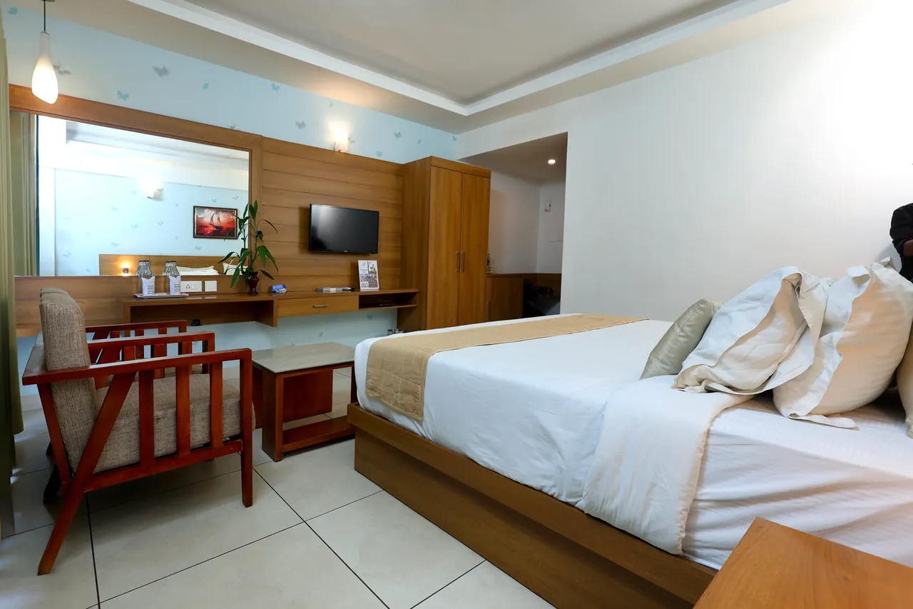 A guest room with a wooden writing desk, armchair and bed