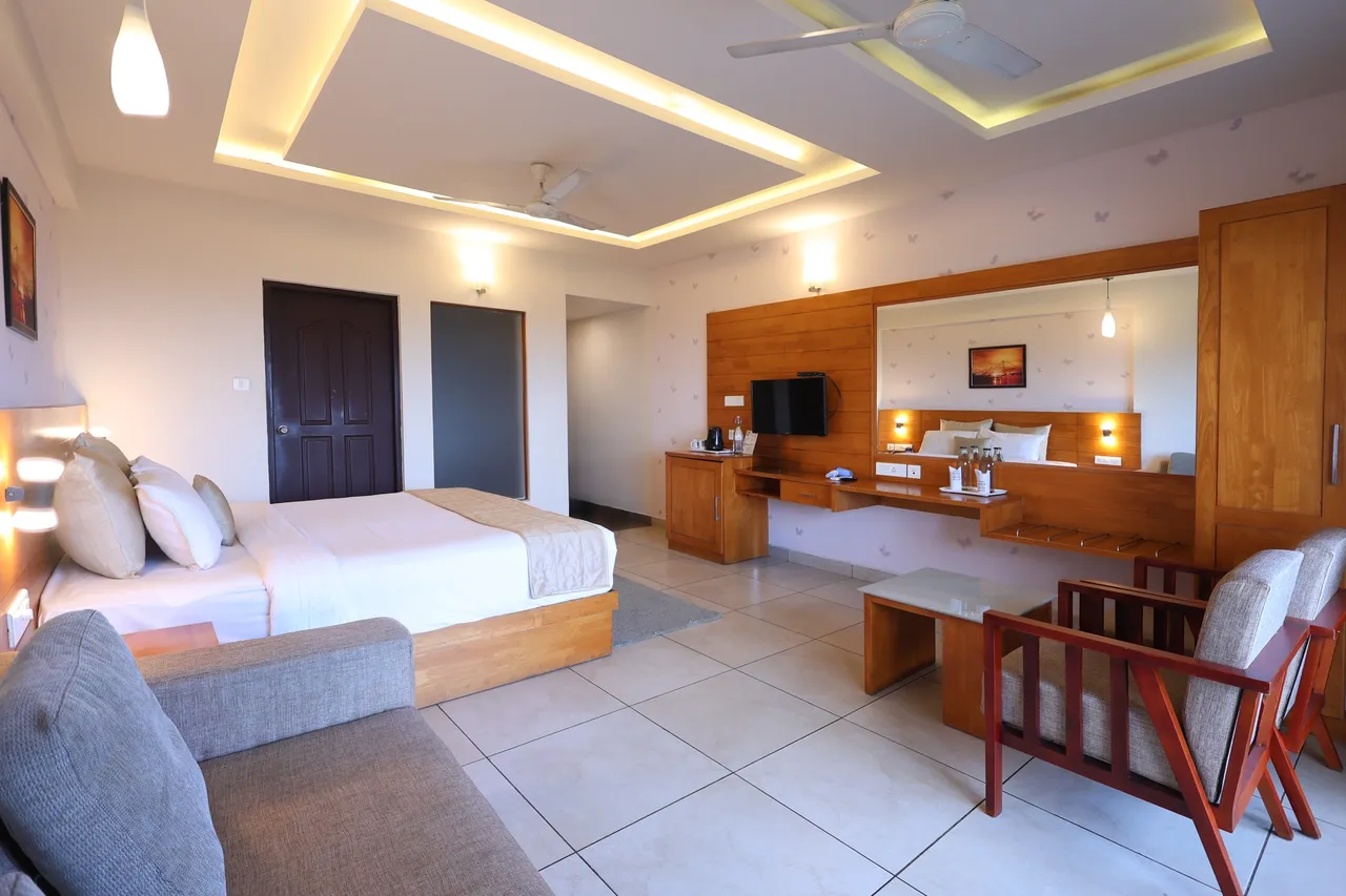A suite with a bed, a sofa and armchairs, and a long wooden dresser