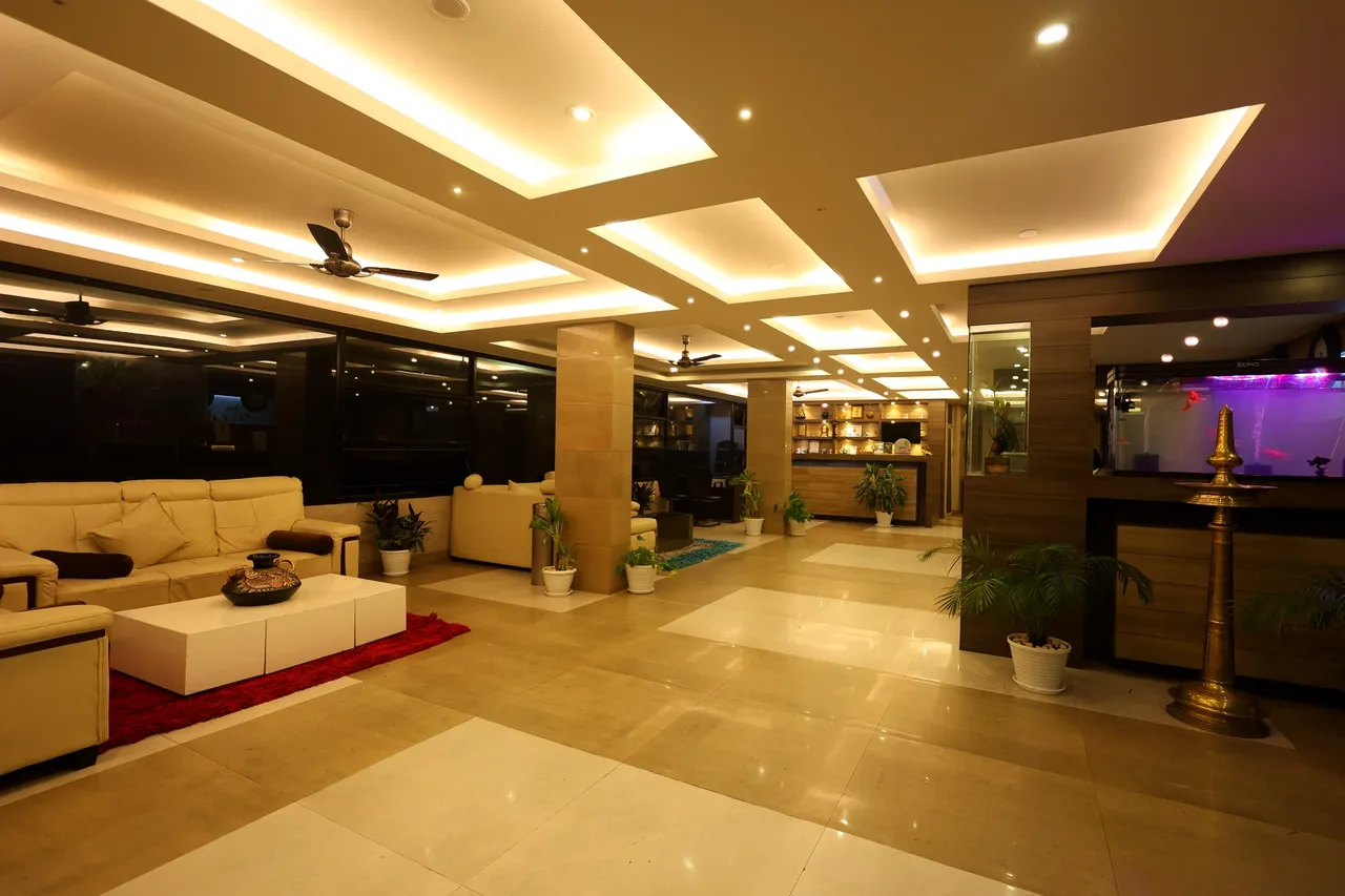 The lobby lounge with white sofas, a brass lamp and the reception beyond