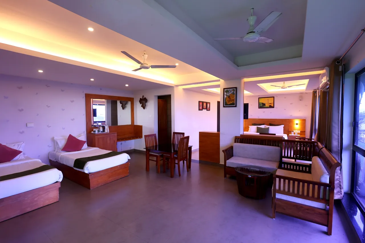 A large suite with beds, a wooden sofa set and a dining table